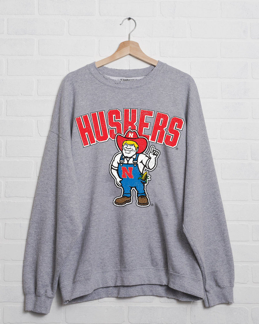 Unique Nebraska Huskers Cartoon Mascot Gray Thrifted Sweatshirt with distressed detailing, 50/50 cotton-poly blend, and unisex fit, perfect for game day, available at Onyx Native.