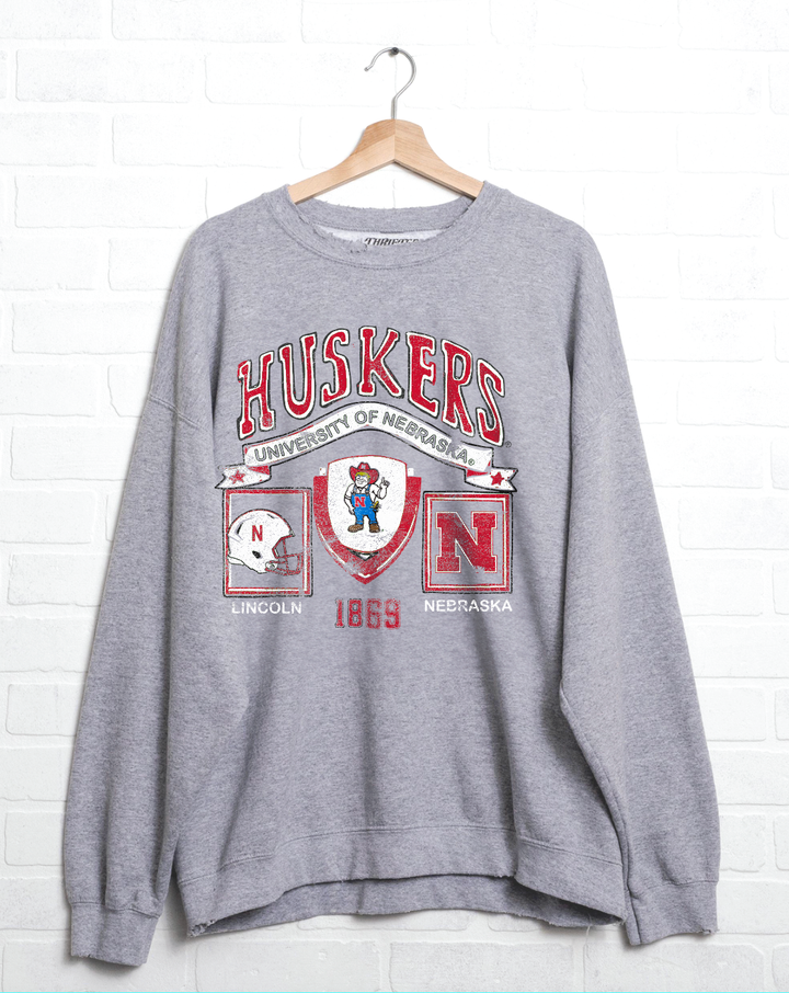 Nebraska Huskers Prep Patch Gray Thrifted Sweatshirt, 50/50 cotton/poly blend, meaningfully distressed and unique. Unisex fit, officially licensed.