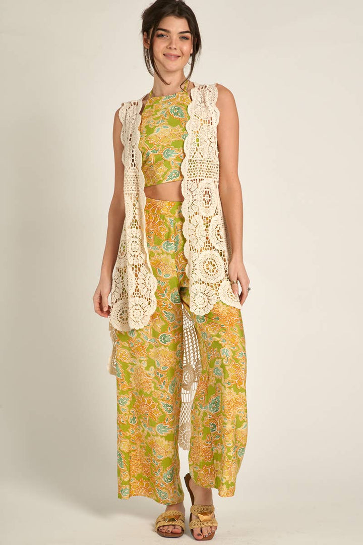 side view of model wearing Elevate your style with our Sleeveless High-Low Crochet Cardigan made from 100% cotton. This versatile piece features a high-low design for a chic look.