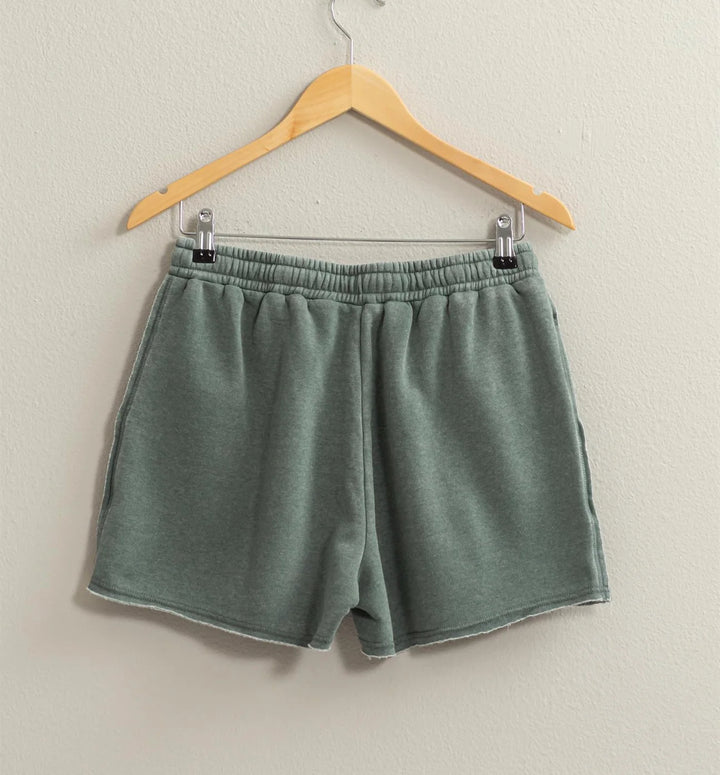 back view of colored Josie Drawstring Lounge Shorts in soft stretch knit with banded waist, adjustable drawstring, and raw-cut hem. Relaxed fit for comfort. Made from 51% cotton and 49% polyester.