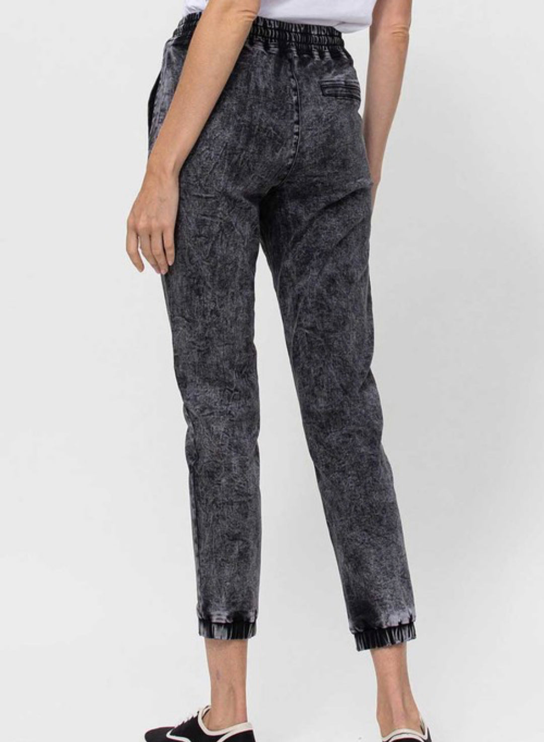 back view of Vervet by Flying Monkey high-waisted jogger pants with drawstring detail, acid wash stretch denim, and relaxed fit. Inseam 25 3/8 inches. Made from 60% cotton, 26% polyester, 11.3% rayon, and 2.7% spandex.