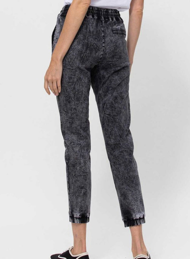 back view of Vervet by Flying Monkey high-waisted jogger pants with drawstring detail, acid wash stretch denim, and relaxed fit. Inseam 25 3/8 inches. Made from 60% cotton, 26% polyester, 11.3% rayon, and 2.7% spandex.
