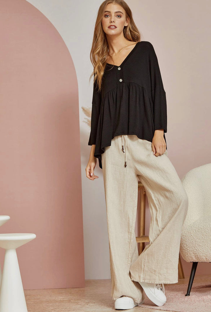 zoomed out view of front of Black babydoll tee with 3/4 sleeves. Made from a blend of 65% polyester, 32% rayon, and 3% spandex. A versatile closet staple
