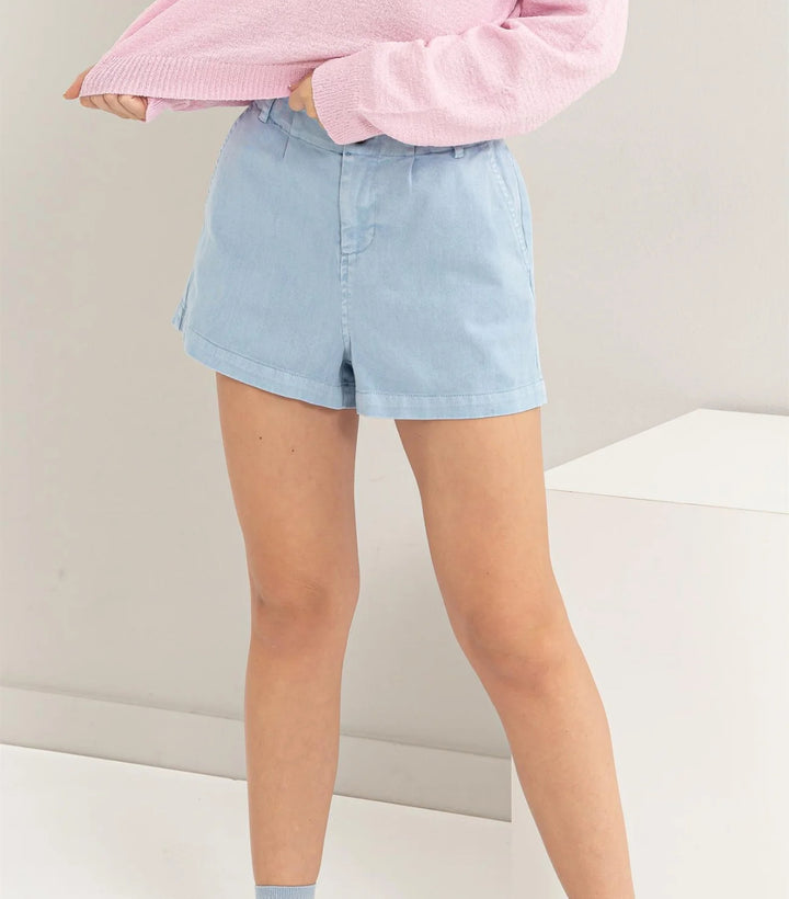 model view of High-waisted shorts featuring pigment garment dyeing, button closure, belt loops, and side pockets. Made from 100% cotton for a carefree summer vibe.