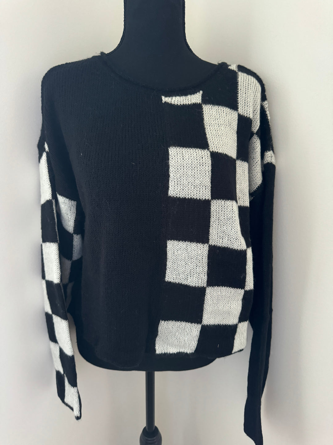 mannequin view of Hit the Track Colorblock Checkered Knit Sweater featuring a boat neckline and long sleeves, made from 100% acrylic, available at Onyx Native.