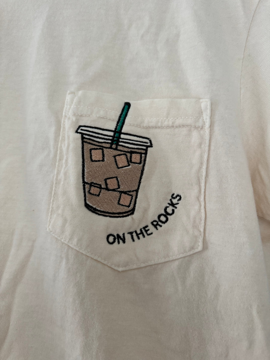 pocket detailed view of 'On the Rocks' Embroidered Pocket Tee in cream with custom colors. Perfect for coffee lovers.