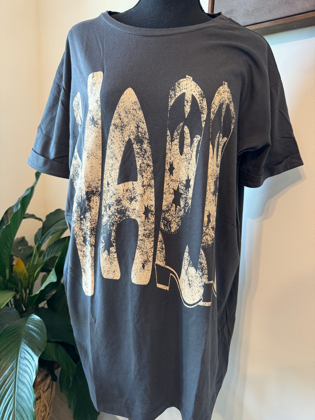 mannequin view of Ya'll Cowboy Boots Vintage Wash Graphic Tee with 'Ya'll' text, stars, and cowboy boots graphics. Oversized fit, mineral washed, round neckline, short cuffed sleeves, and dropped shoulders
