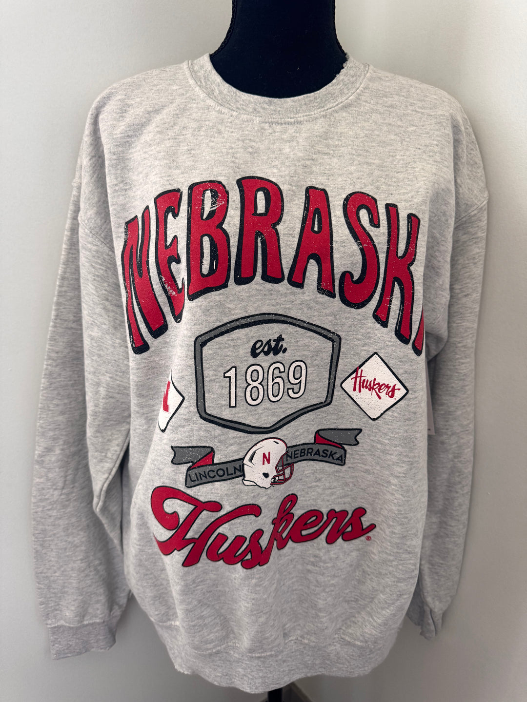 Nebraska Huskers Patches Sweatshirt — distressed thrifted ash gray crew, unisex fit, officially licensed graphic by Onyx Native