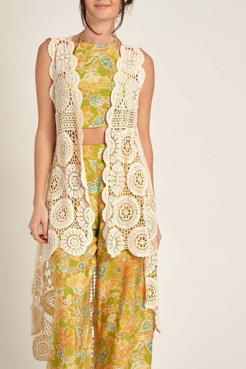 styled view of Elevate your style with our Sleeveless High-Low Crochet Cardigan made from 100% cotton. This versatile piece features a high-low design for a chic look.