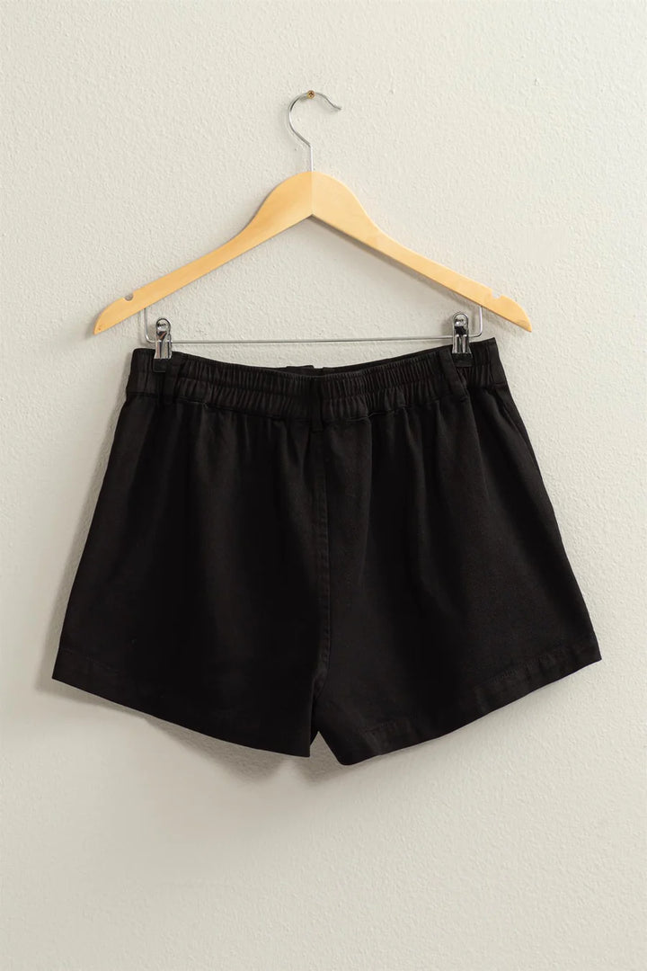 back view of High-waisted shorts featuring pigment garment dyeing, button closure, belt loops, and side pockets. Made from 100% cotton for a carefree summer vibe.
