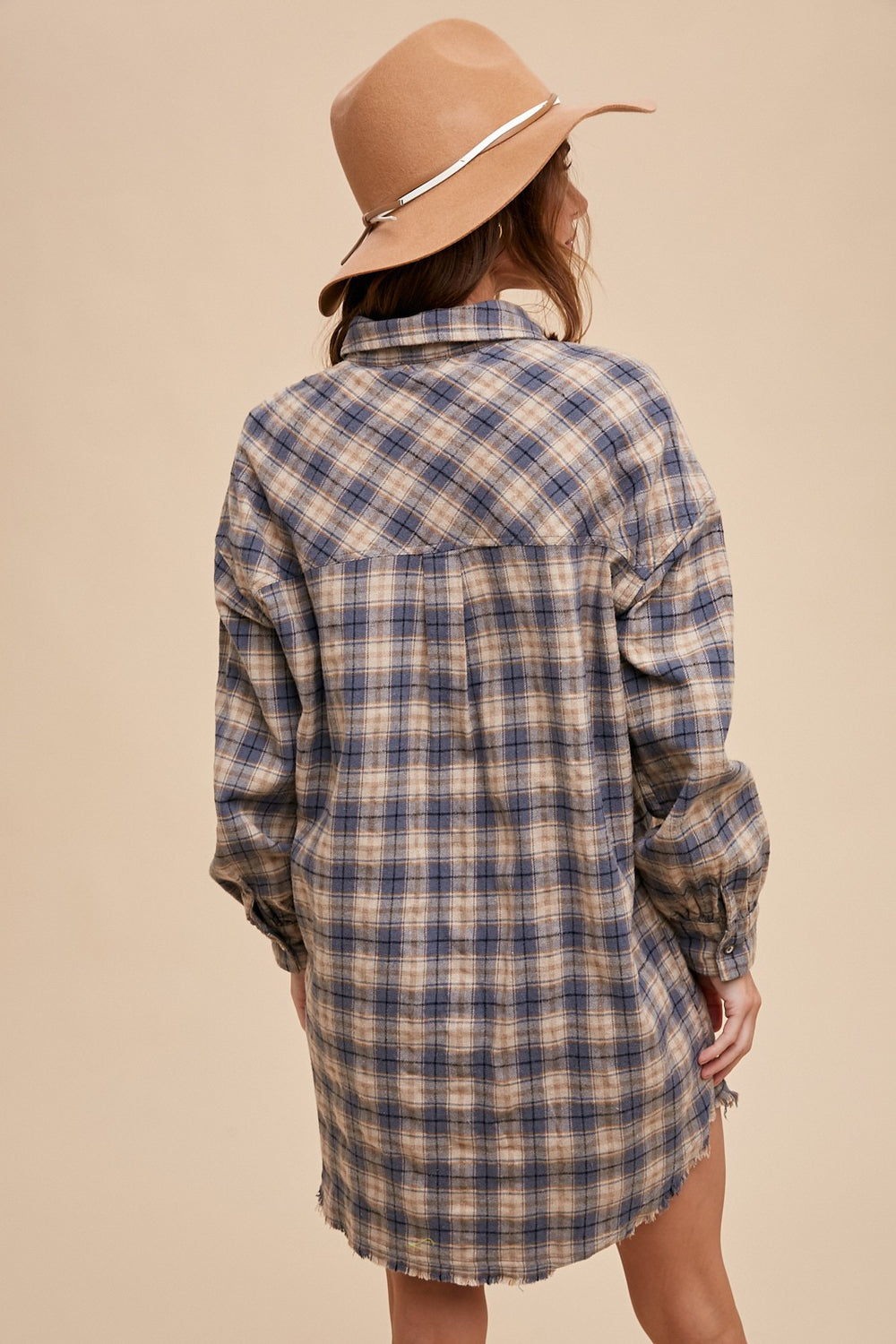 back view of Button-up plaid shirt dress with breast pockets and button closures on cuffs. Made from 60% cotton and 40% polyester. Can be worn as a dress or shacket.