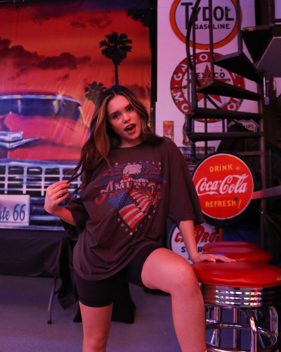 model with Vintage-inspired graphic thrifted tee made from 100% preshrunk cotton. Features meaningful distressing, with each piece being one of a kind. Unisex fit with colors and distressing that may vary. Pairs well with vintage denim and sneakers.