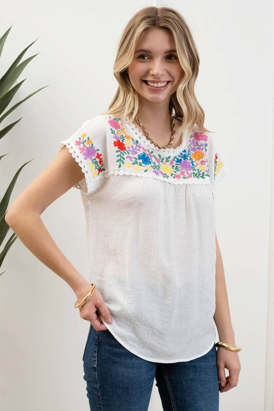 side view of Whitney Floral Embroidery Blouse with a round neckline, short sleeves, and scallop lace trim. Made from 86% rayon and 14% nylon with a contrast of 100% polyester.