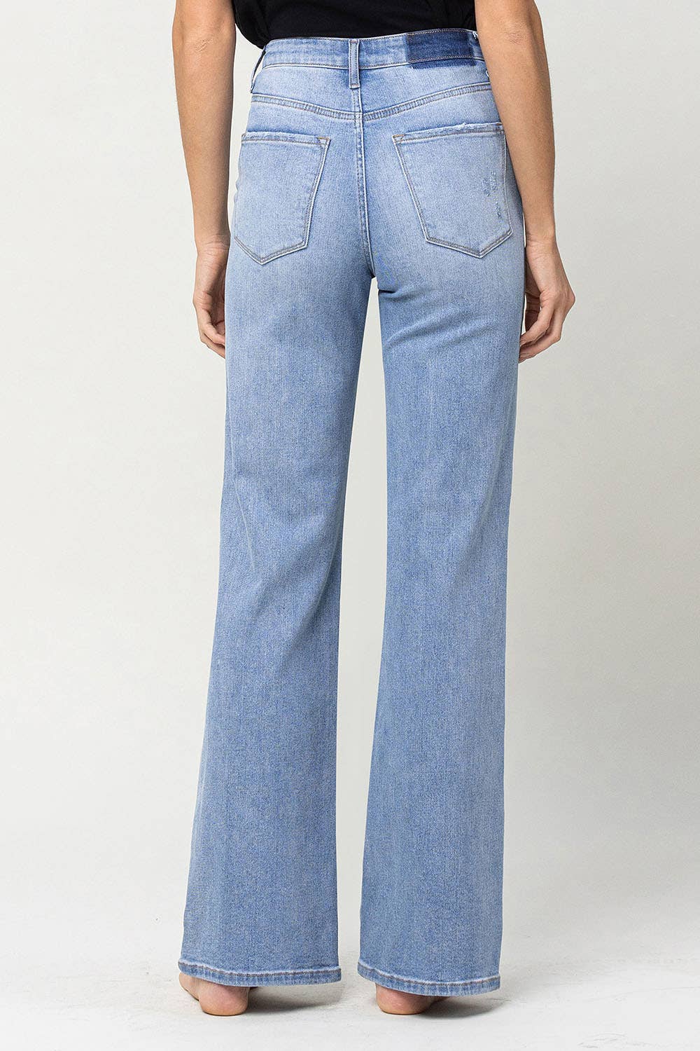 full length view of back on 90's vintage super high rise flare jeans with comfort stretch denim, full length, and flare legs. Front rise: 11.5 inches, inseam: 32 inches, leg opening: 20 inches. Model is 5'9'' wearing size 26.