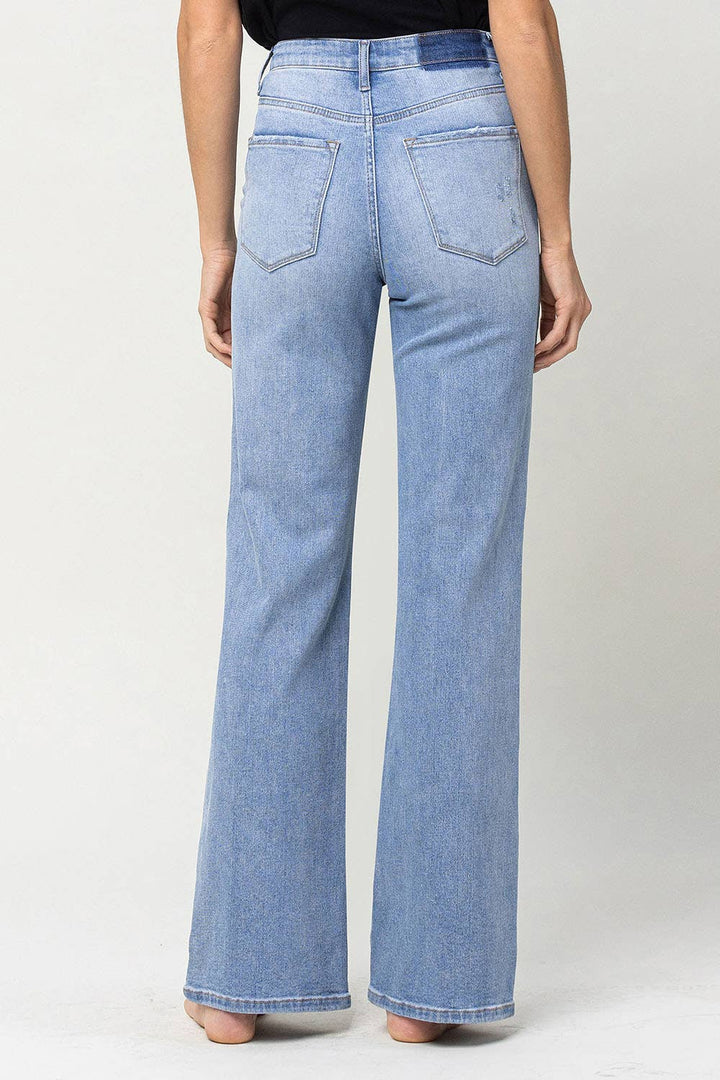 full length view of back on 90's vintage super high rise flare jeans with comfort stretch denim, full length, and flare legs. Front rise: 11.5 inches, inseam: 32 inches, leg opening: 20 inches. Model is 5'9'' wearing size 26.