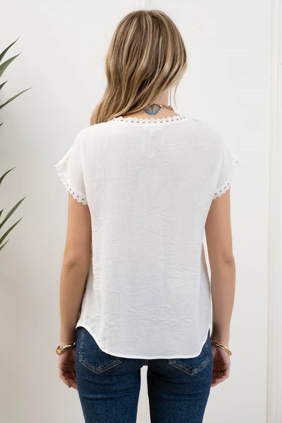 back view of Whitney Floral Embroidery Blouse with a round neckline, short sleeves, and scallop lace trim. Made from 86% rayon and 14% nylon with a contrast of 100% polyester.