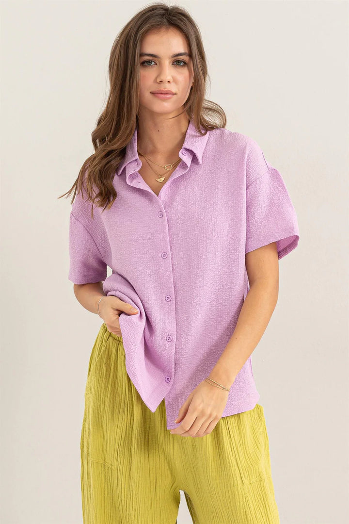 front view of Lavender Haze Button Down Shirt - Textured fabric with point collar, drop shoulders, short sleeves, and a relaxed fit. Tuck-in option for a polished look.