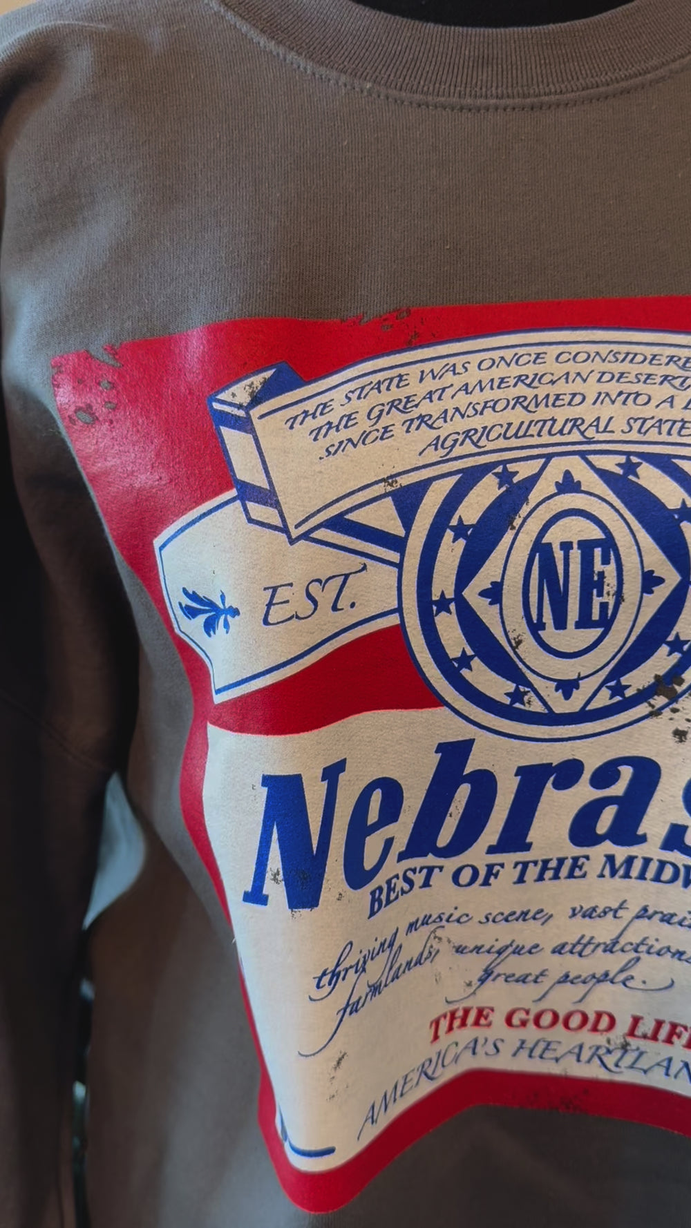 video of detail on Nebraska Beer Crewneck, charcoal Gildan sweatshirt, relaxed fit, size up for an oversized look.