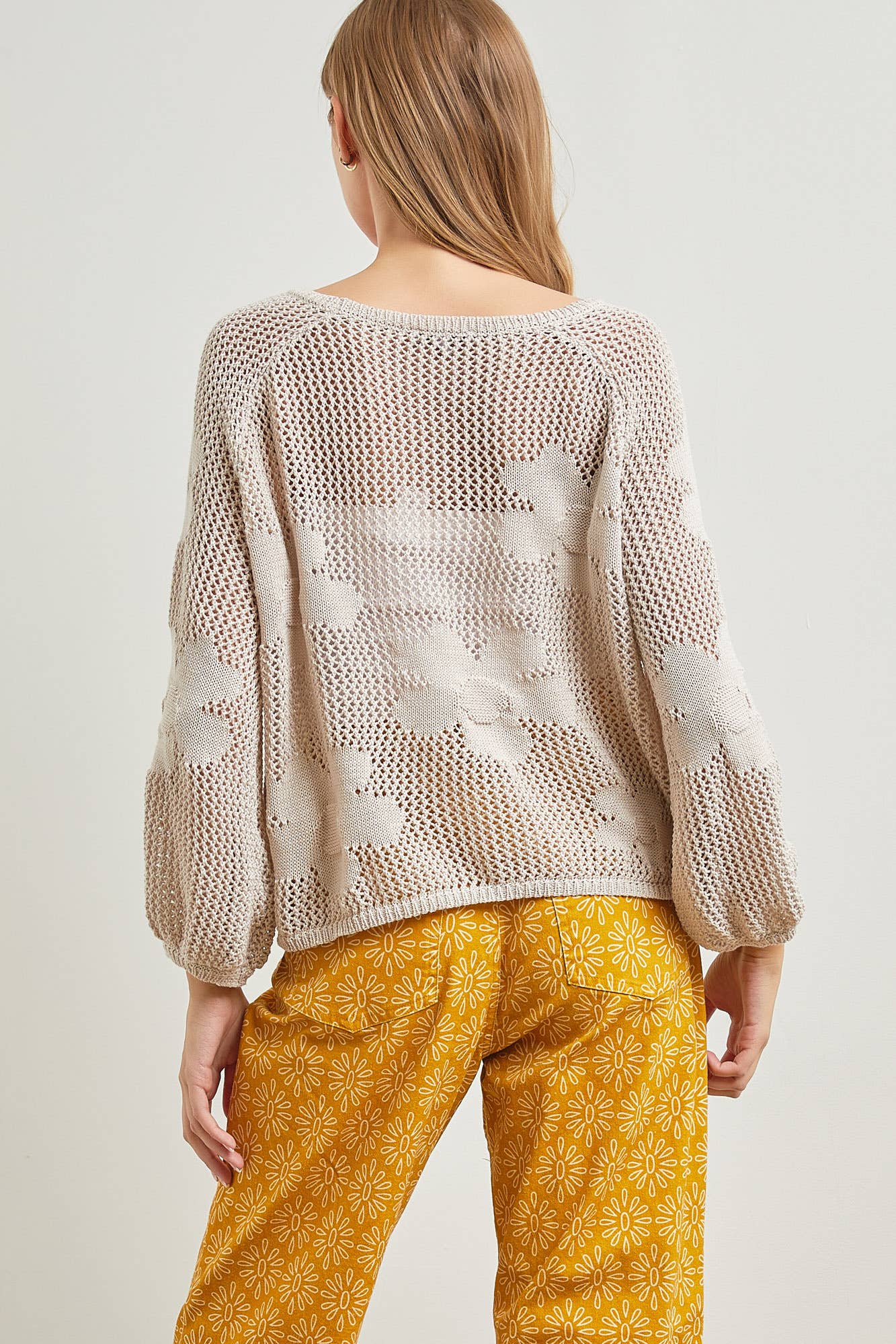 back view of "Flower Fishnet Knit Long Sleeve Top, round neck, featuring flower detail, model is wearing size S.