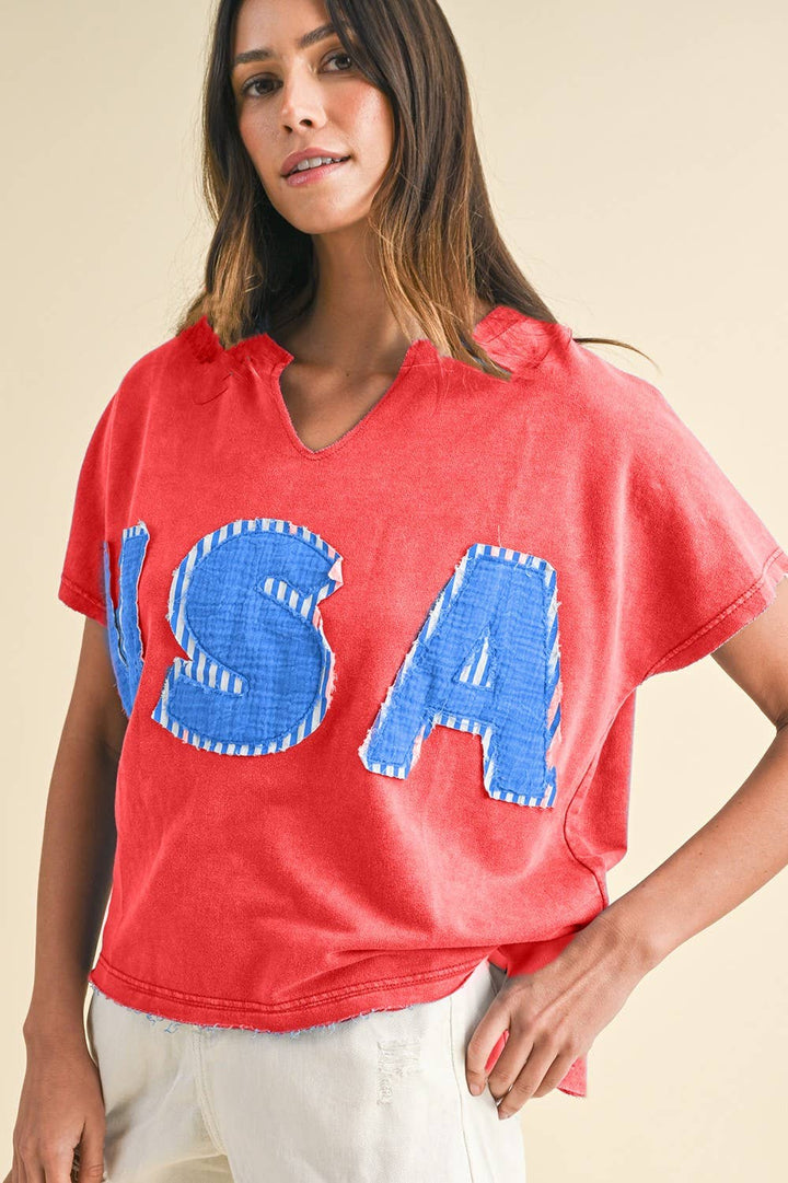red colored Mineral Washed USA Patched Knit Top with mixed fabric lettering patch, lightweight French terry, notched neckline, short dolman sleeves, raw edge details, and loose fit.
