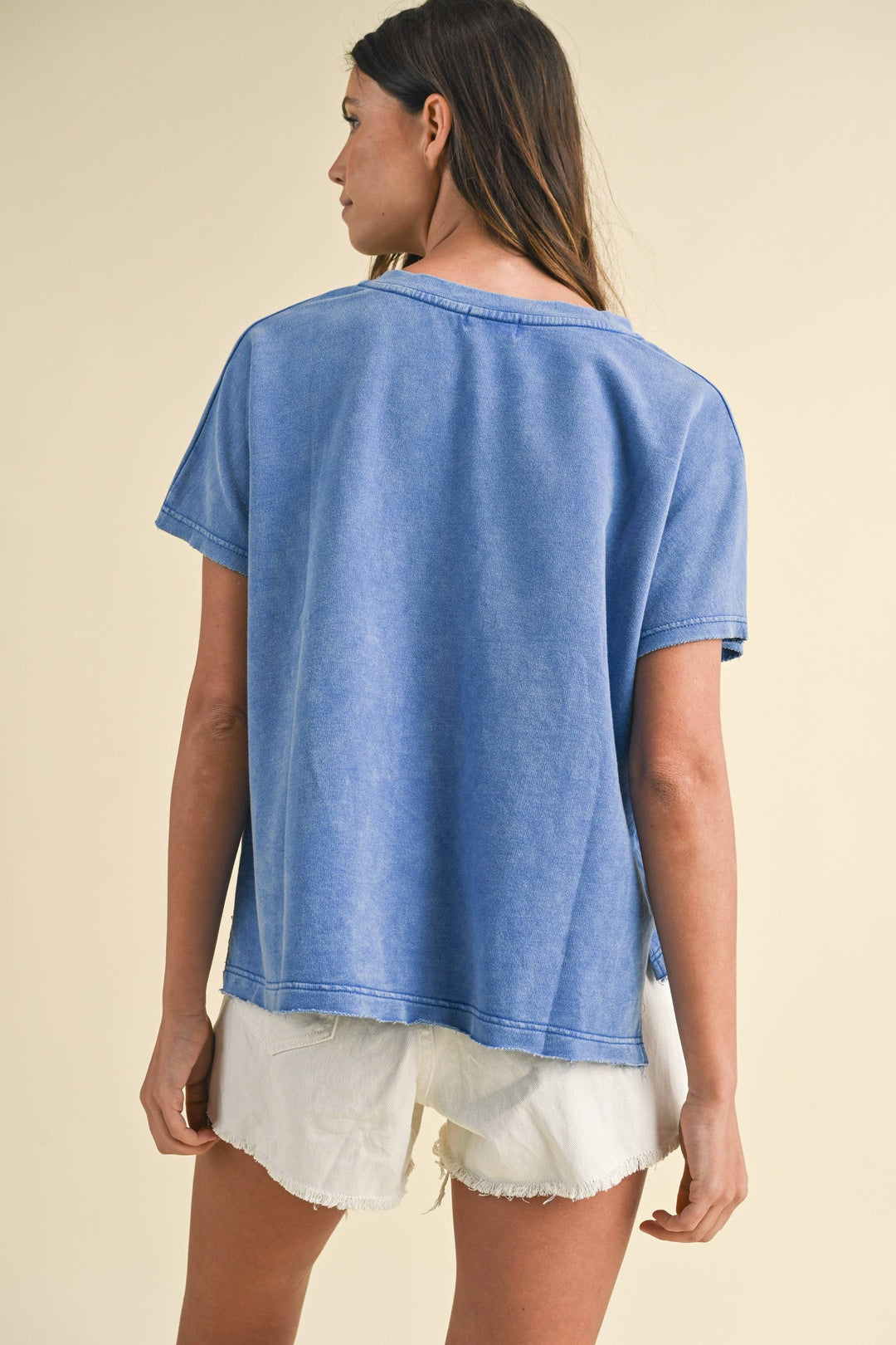back view of Mineral Washed USA Patched Knit Top with mixed fabric lettering patch, lightweight French terry, notched neckline, short dolman sleeves, raw edge details, and loose fit.