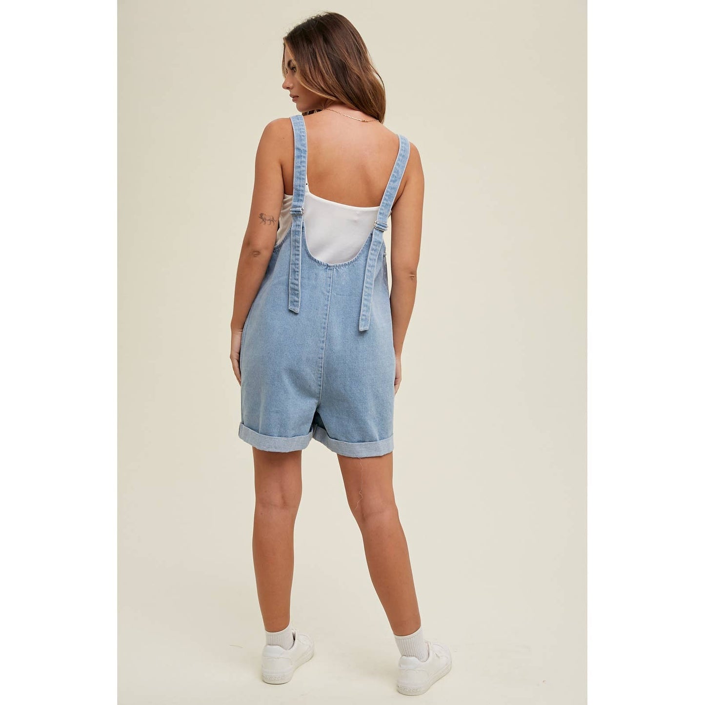 back view of Cotton Denim Seam Detail Romper with adjustable straps and front pockets, made of 100% cotton. Available for pre-order with color variations possible due to lighting and monitor differences.