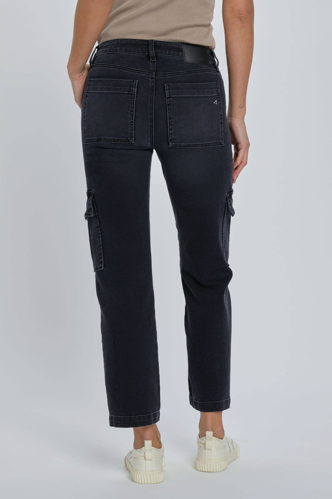 back view of Black stretch cargo pocket straight jeans. Features include a rise of 10 inches and an inseam of 28 inches. Model is wearing size 26. Made of 65% cotton, 21% rayon, 11% polyester, and 2% spandex.
