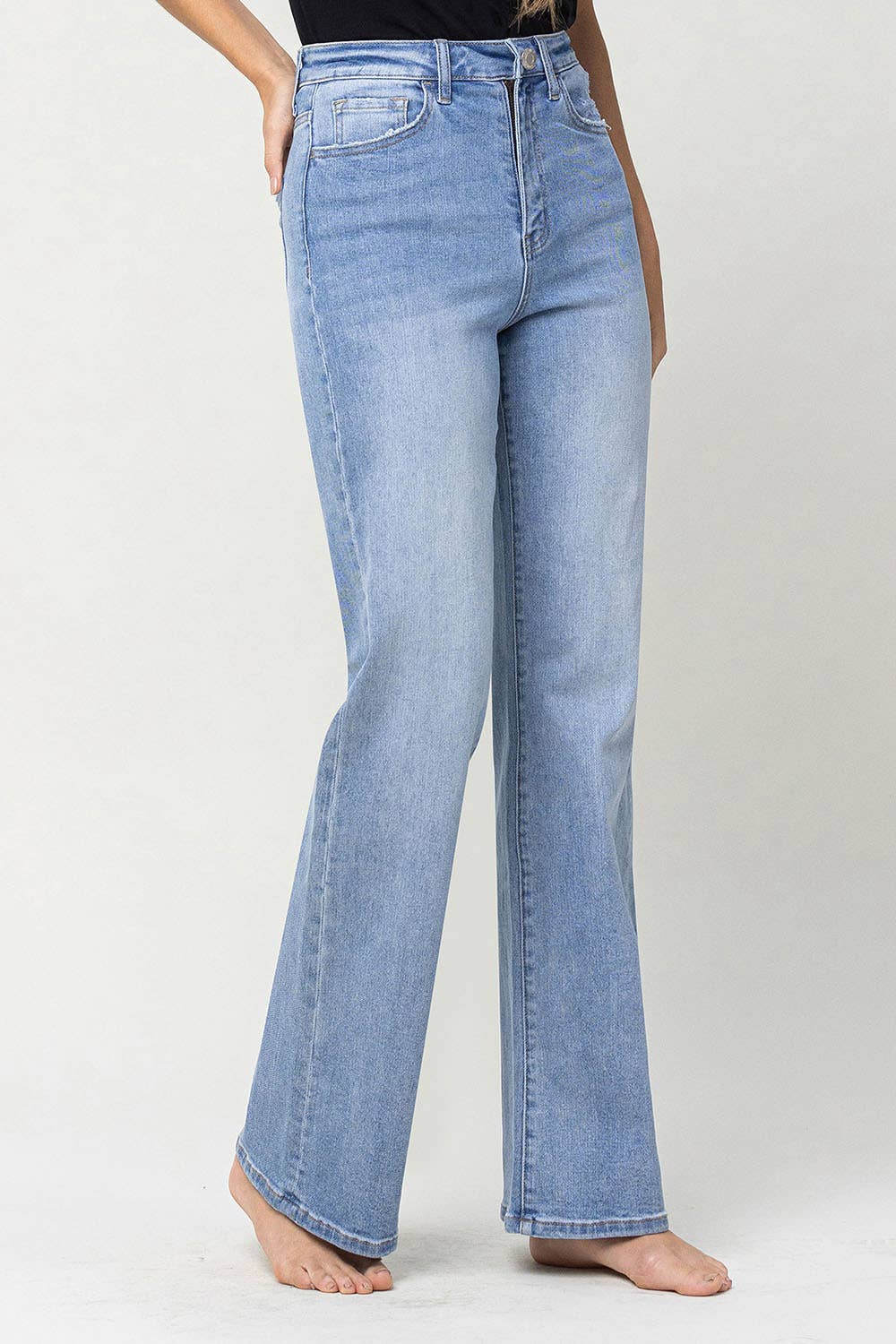 slight right side view of 90's vintage super high rise flare jeans with comfort stretch denim, full length, and flare legs. Front rise: 11.5 inches, inseam: 32 inches, leg opening: 20 inches. Model is 5'9'' wearing size 26.