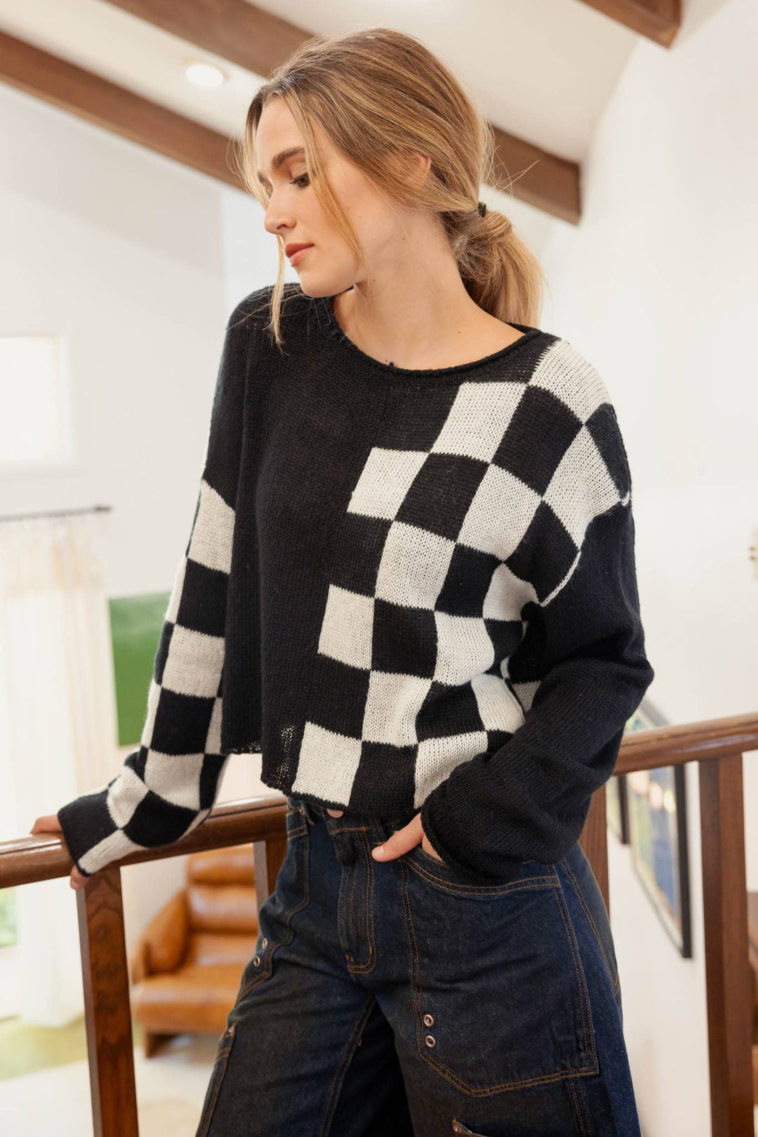 slight side view of Hit the Track Colorblock Checkered Knit Sweater featuring a boat neckline and long sleeves, made from 100% acrylic, available at Onyx Native.