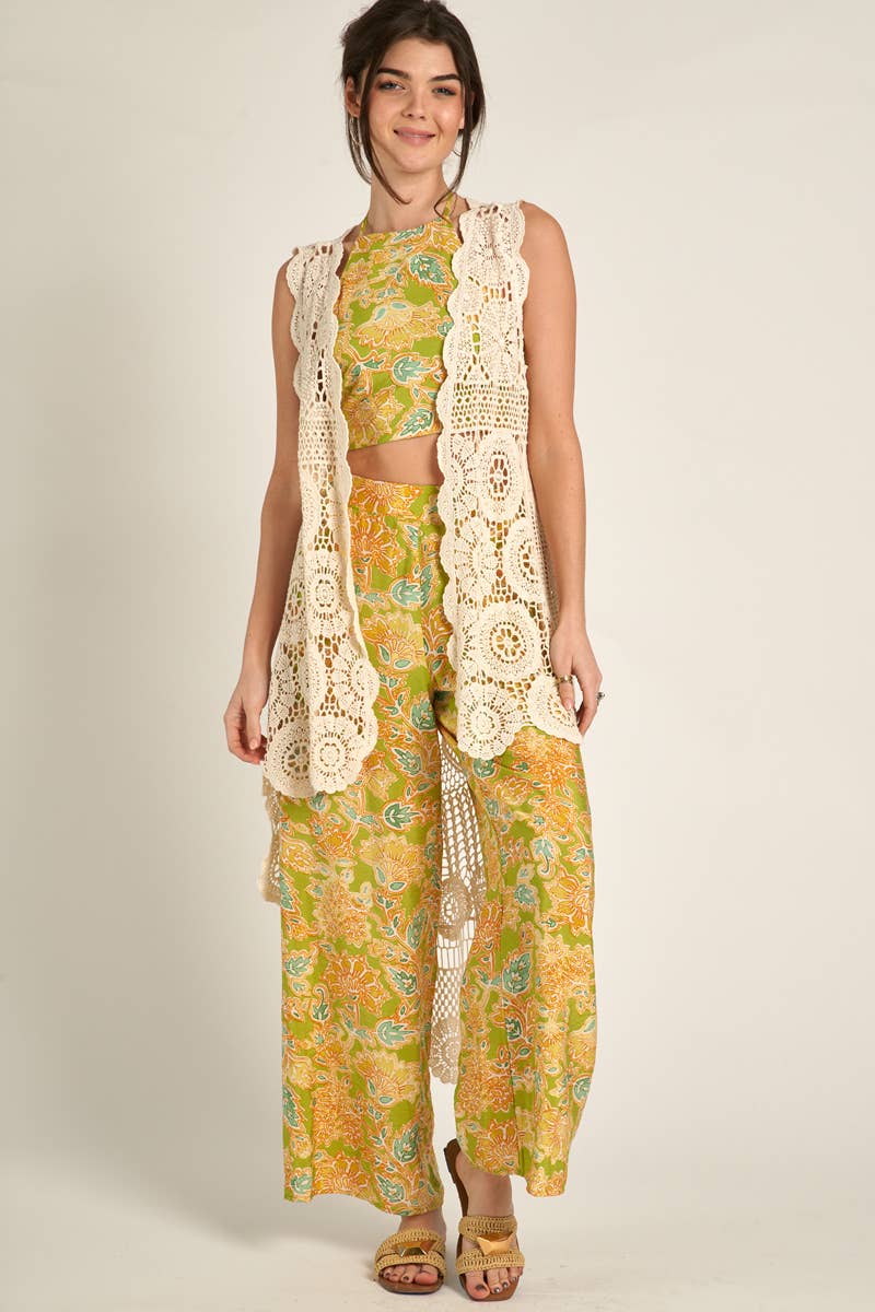 side view of model wearing Elevate your style with our Sleeveless High-Low Crochet Cardigan made from 100% cotton. This versatile piece features a high-low design for a chic look.