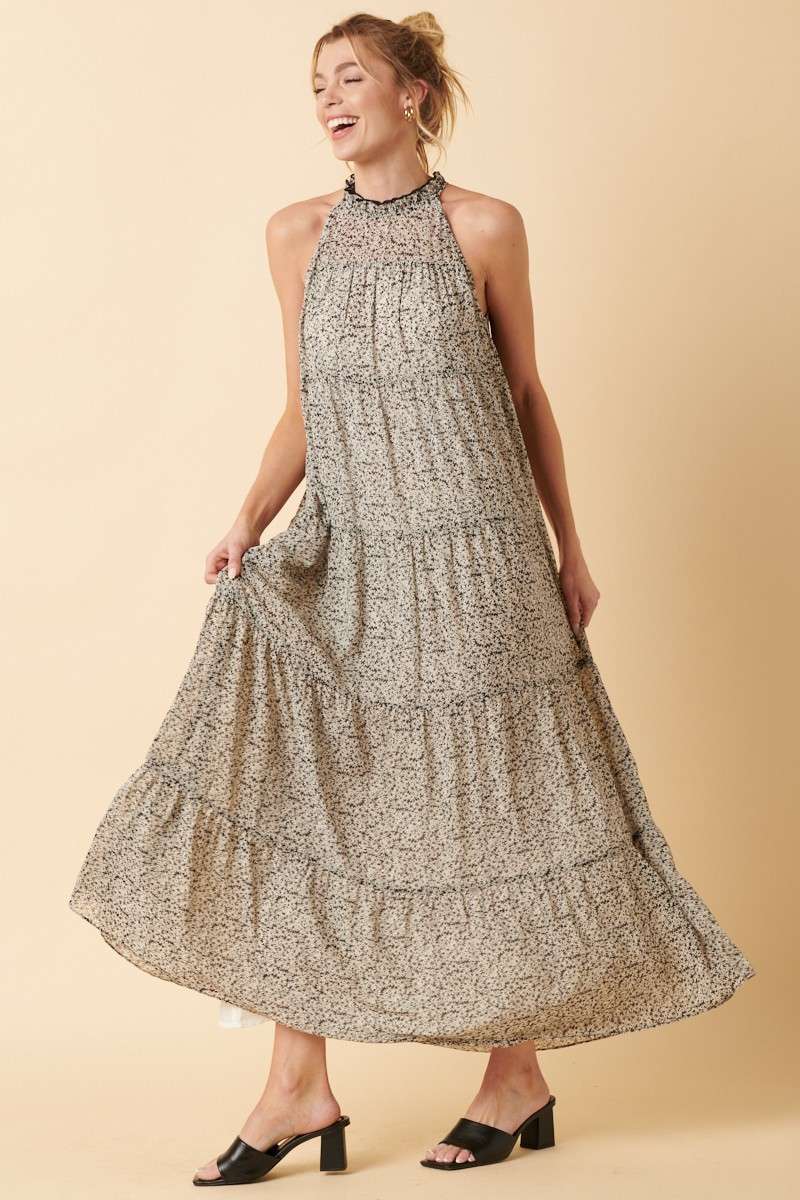 Sally Flower Halter Maxi Dress with flower print on chiffon fabric, ruffle mock neck, tie back, sleeveless halter design, and tiered detail. Maxi length for an elegant silhouette.