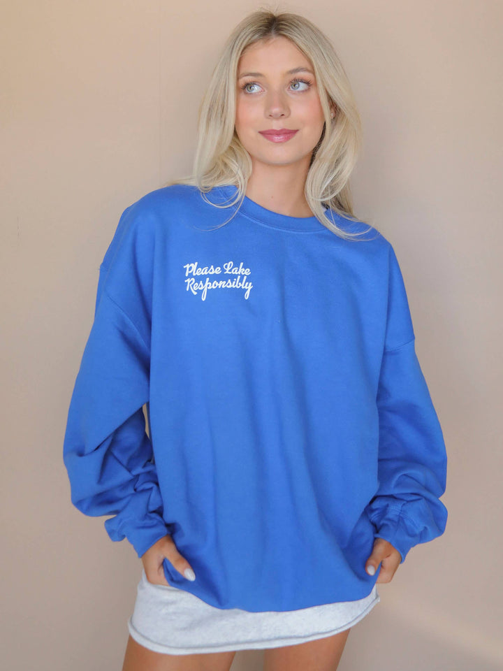 front view of Lake Responsibly' Sweatshirt in blue crewneck, perfect for stylish lake days. Ideal gift when paired with a drink sleeve. Emphasizes responsible enjoyment of lake activities.