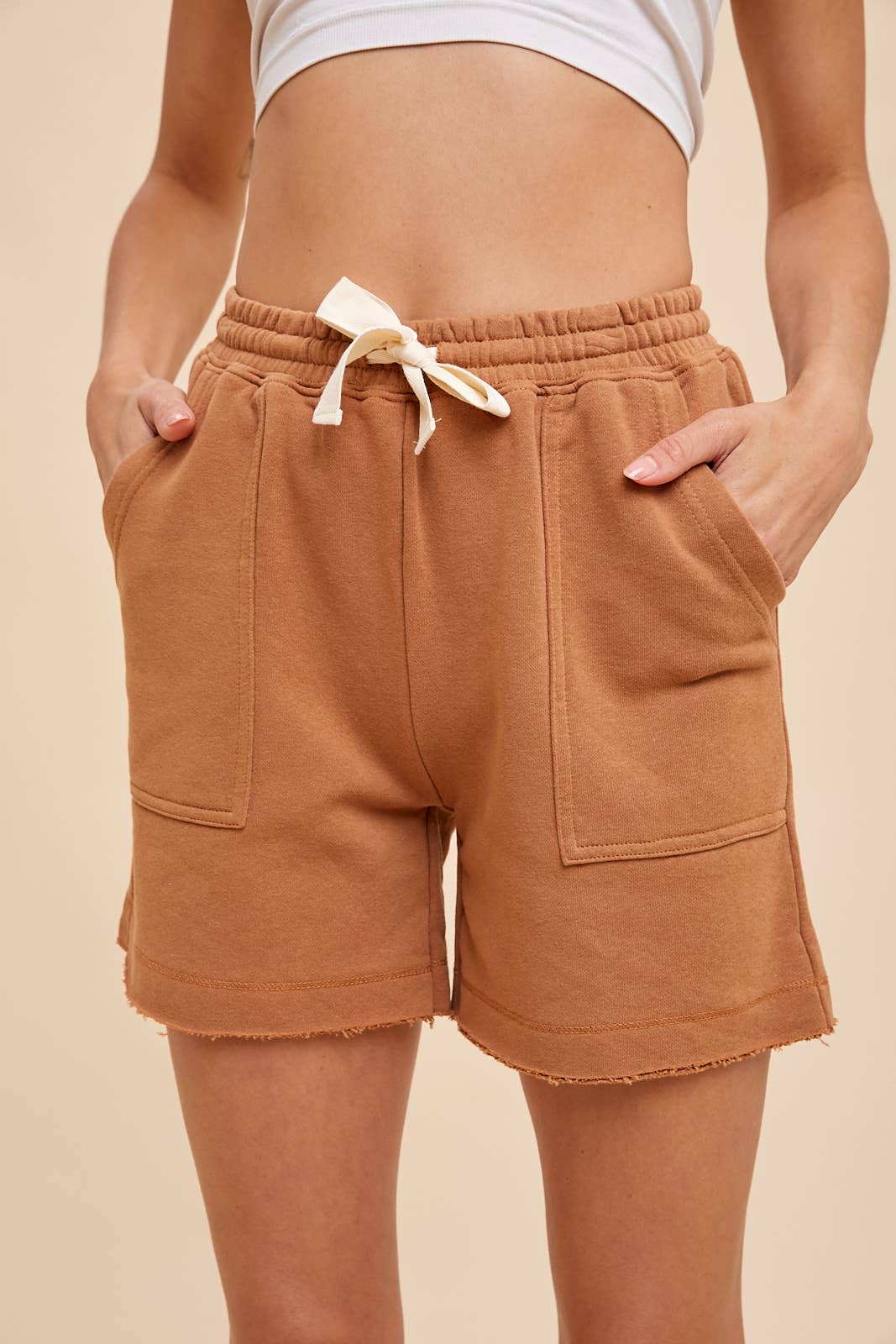 front view of Cammy Short - Garment-washed French terry shorts with an elastic waistband, cotton tape drawstring, double edge raw fray hem detail, and deep pockets.