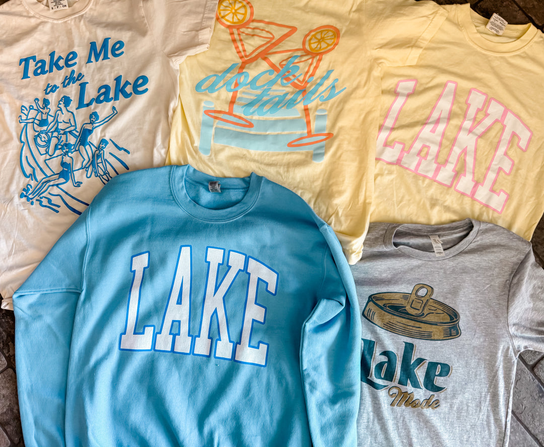 pile of tees Take Me to the Lake Tee — cream Comfort Colors® tee with vintage blue lake graphic, Jo Johnson Overby collaboration by Onyx Native

