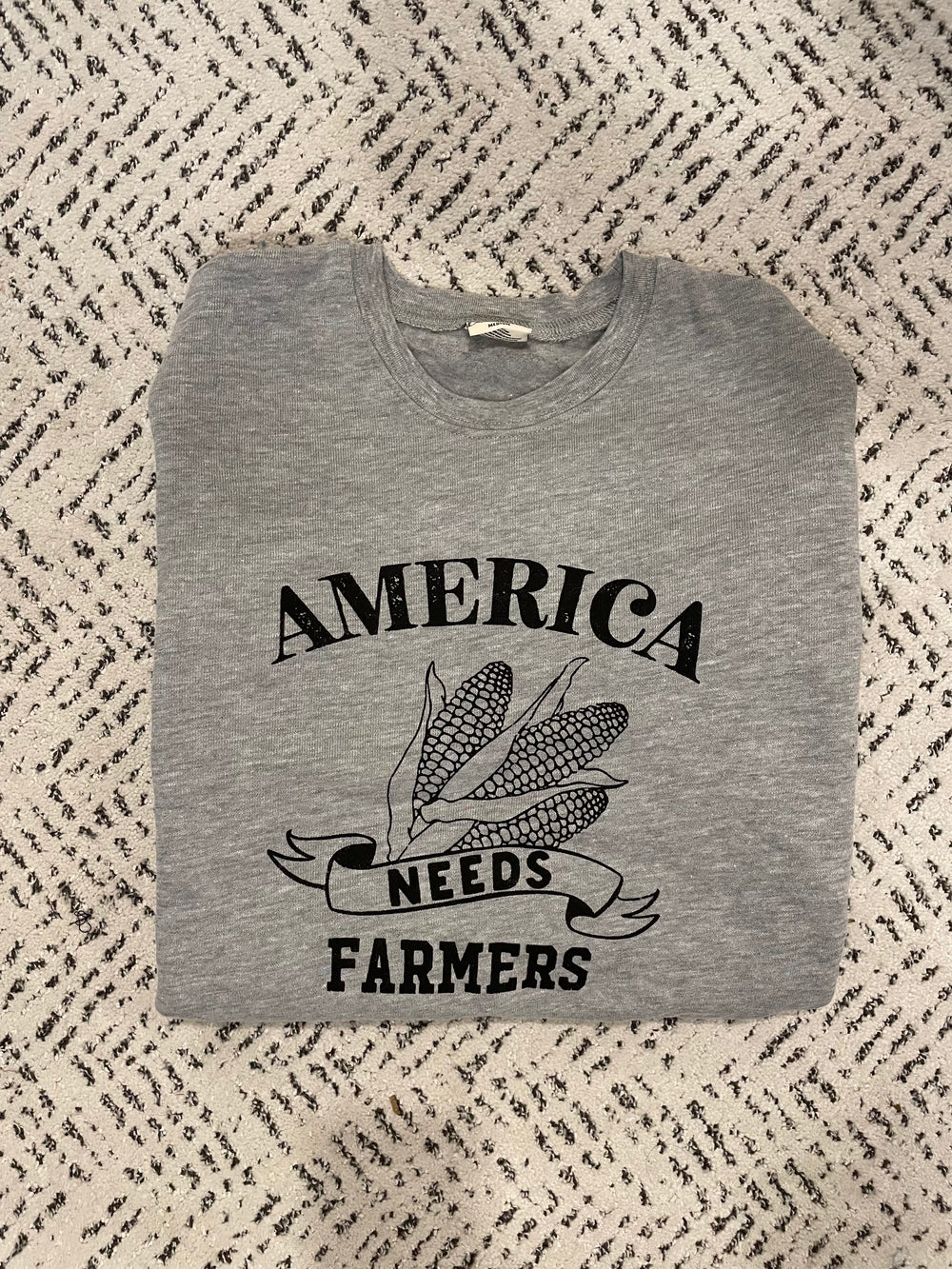 real view of America Needs Farmers graphic sweatshirt in unisex fleece pullover style. Spun from plush sponge fleece fabric, it features a relaxed fit, crewneck, ribbed cuffs and waistband. Soft and perfect for daily wear and year-round layering.