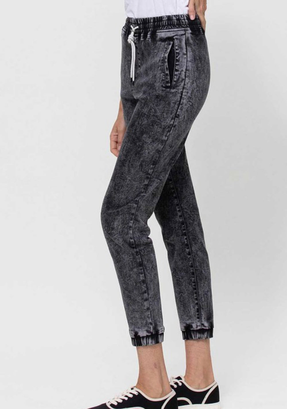 right side view of Vervet by Flying Monkey high-waisted jogger pants with drawstring detail, acid wash stretch denim, and relaxed fit. Inseam 25 3/8 inches. Made from 60% cotton, 26% polyester, 11.3% rayon, and 2.7% spandex.