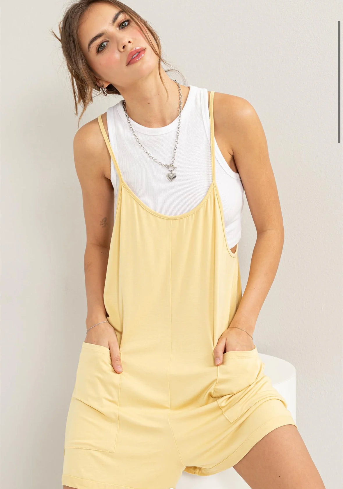 Sunshine Romper in soft jersey with scoop neck, spaghetti shoulder straps, and front patch pockets. Relaxed fit for comfortable wear.
