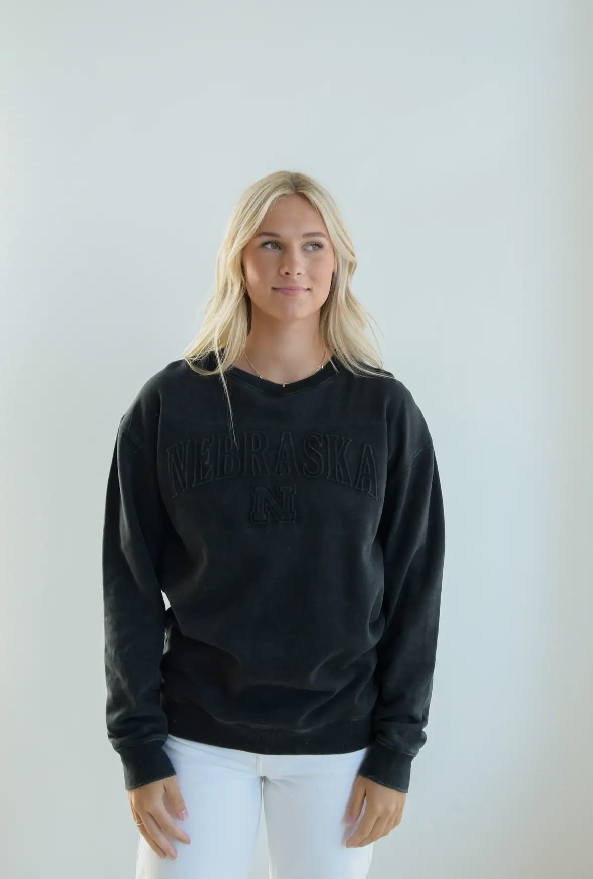 styled view of Black Embossed Husker crewneck with unisex relaxed fit, perfect for game day.