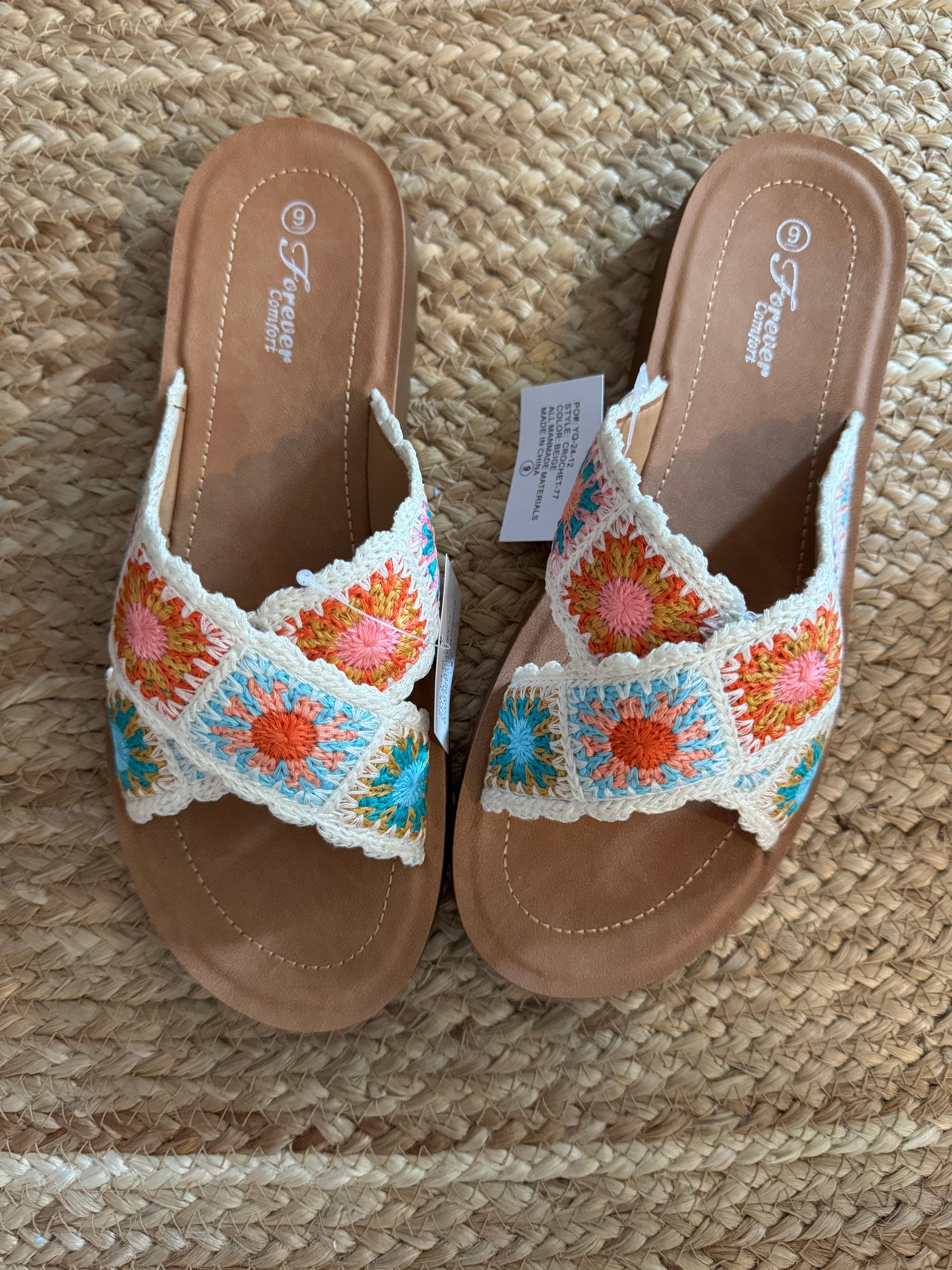 real view of Granny Square Floral Crochet Slide Sandal in beige with cross-strap design, colorful floral crochet pattern, wide double straps, round toe, and rubber outsole.