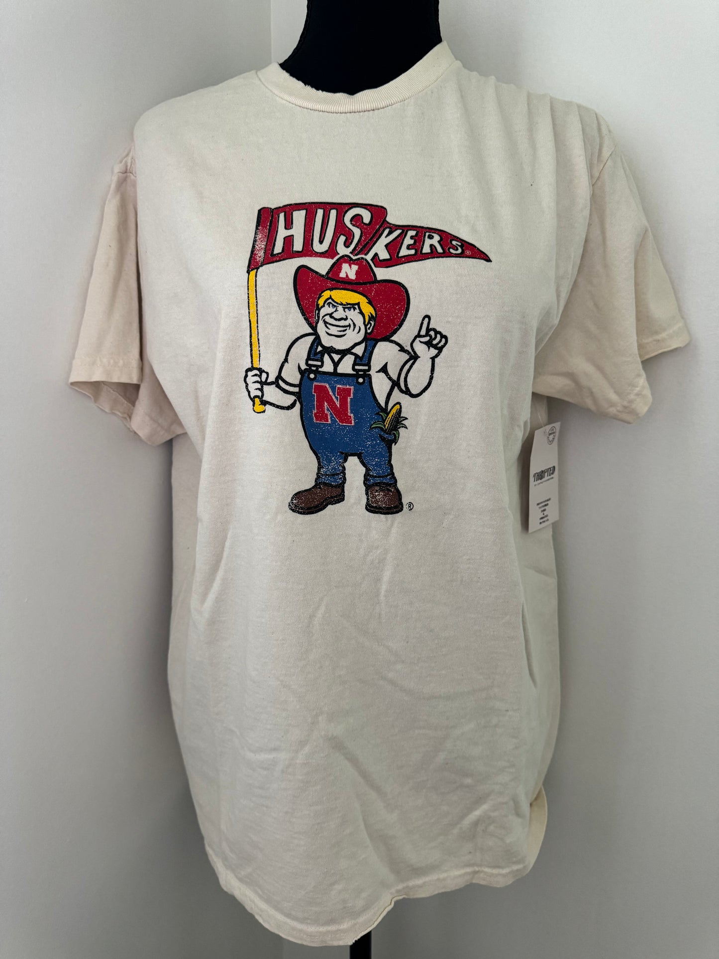 mannequin view of Nebraska Huskers Mascot Flag Game Day Tee - Vintage-inspired 100% preshrunk cotton shirt with unique distressing, unisex fit, officially licensed, pairs well with vintage denim