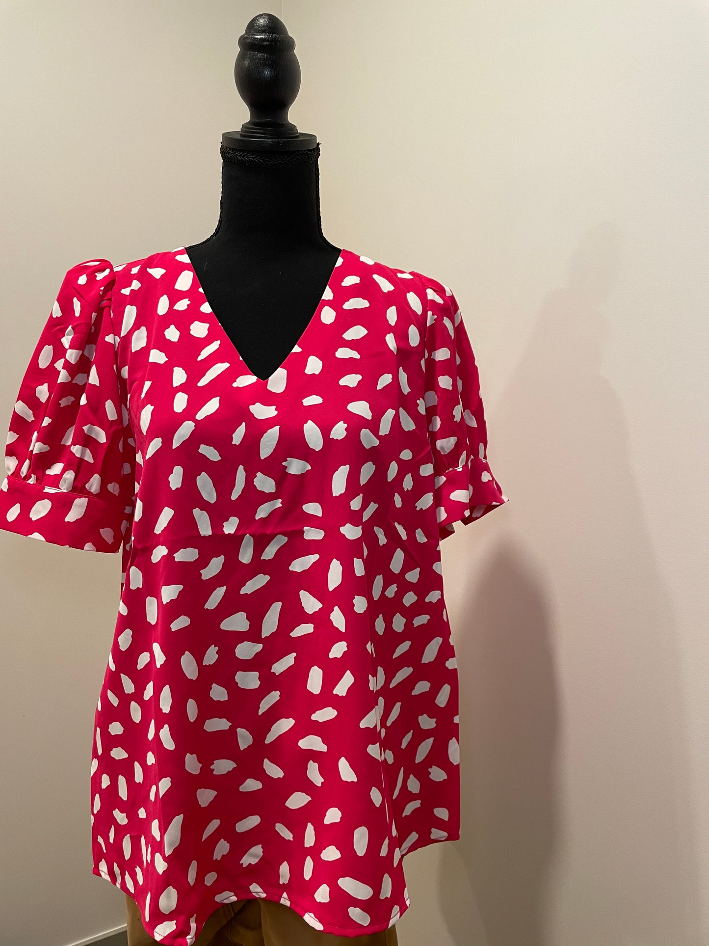 mannequin view of Barbie Pink Leopard V-neck top with tucked sleeves and angled cuffs. Lightweight, unlined, and non-sheer. Runs true to size.