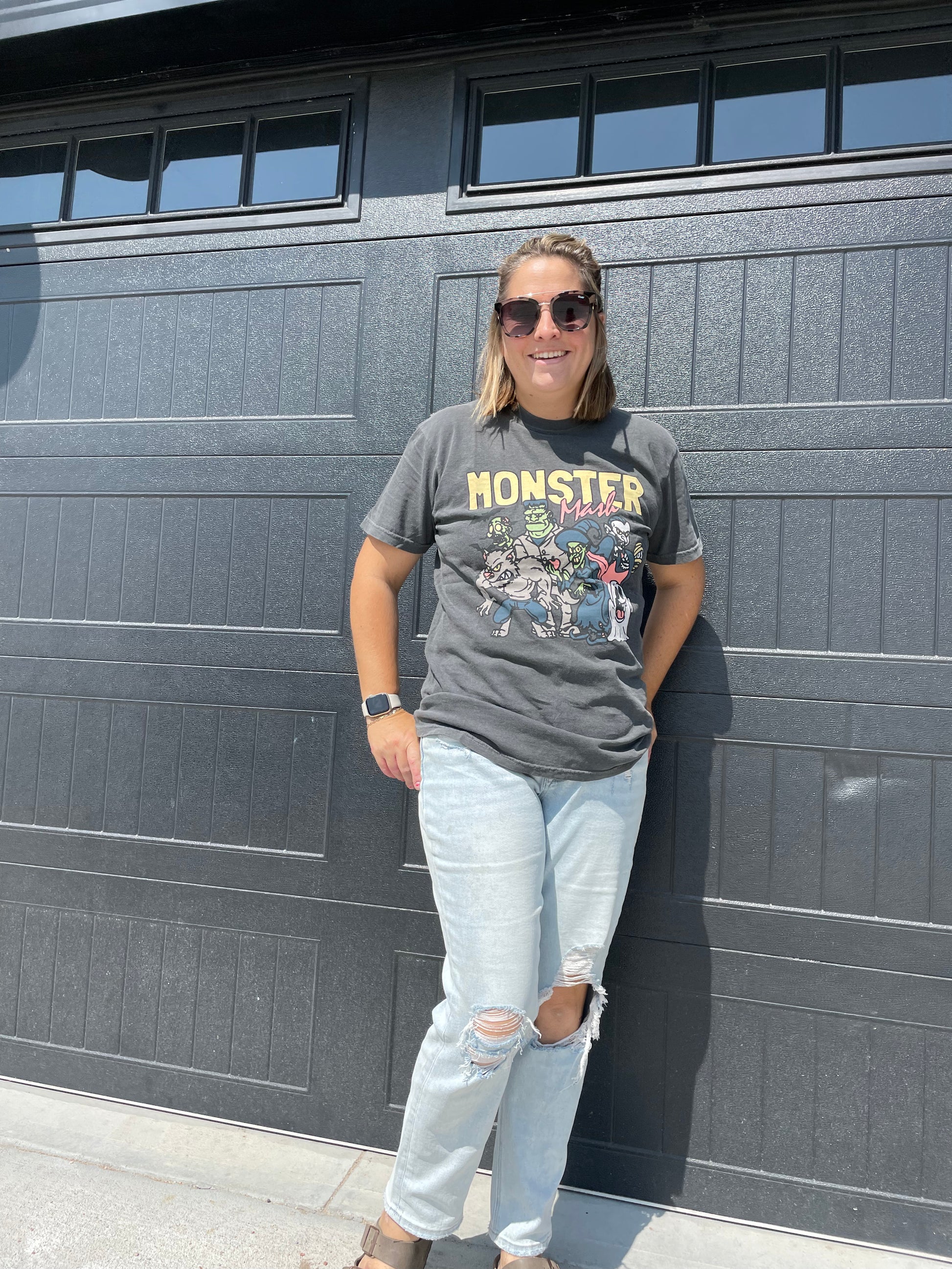 model wearing Monster Mash pigment dyed tee in pepper color with heat-pressed decoration. Made from 100% US ring spun cotton with a soft-washed, garment-dyed finish, featuring a classic rib collar and double-needle hems.