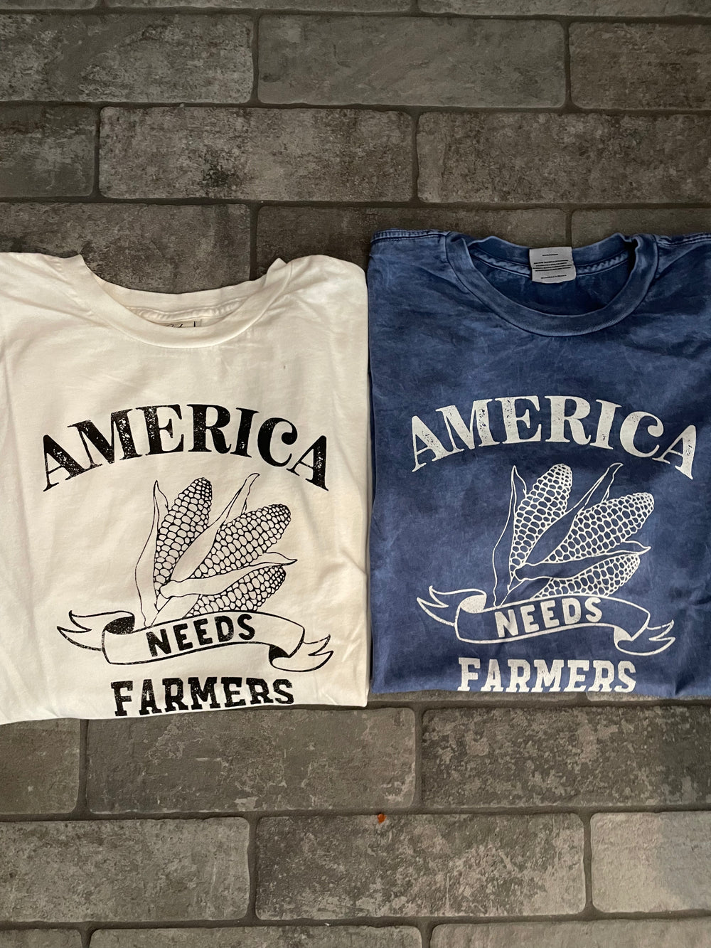 real view of America Needs Farmers mineral washed graphic top made from 100% premium cotton jersey. Relaxed unisex fit with screen-printed design using water-based ink. Each garment is unique due to the dying process. Exclusive Oat Collective label.