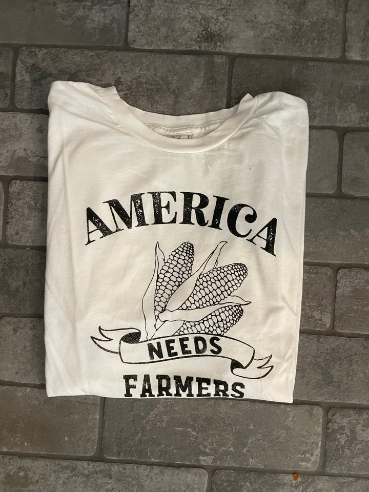 real view of America Needs Farmers mineral washed graphic top in 100% premium cotton jersey. Features a relaxed unisex fit and screen-printed design with water-based ink. Each top is unique due to the dying process. Exclusive Oat Collective label.