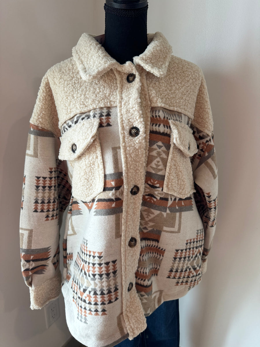 Aztec graphic oversized Sherpa jacket shacket with long sleeves, drop shoulders, patch pockets, and a round hem. Features a button-up front and western jacket design. Model is 5'9" wearing size Small; runs slightly oversized.