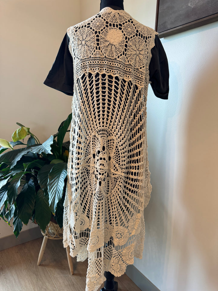 mannequin view of Elevate your style with our Sleeveless High-Low Crochet Cardigan made from 100% cotton. This versatile piece features a high-low design for a chic look.