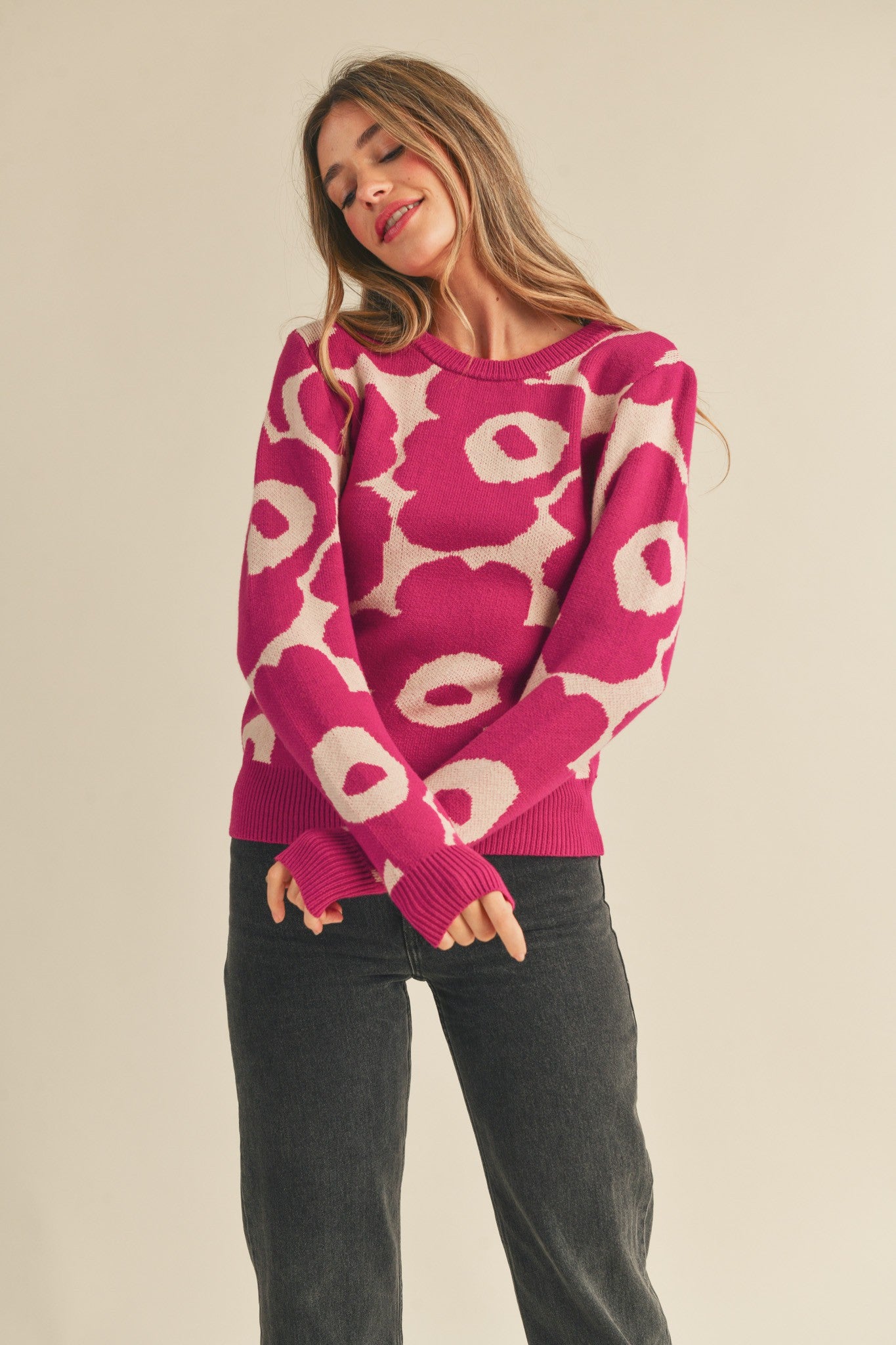 Abstract floral knit sweater in magenta cream with a ribbed crewneck, long sleeves, and relaxed fit. Ribbed neckline, cuffs, and hem. 