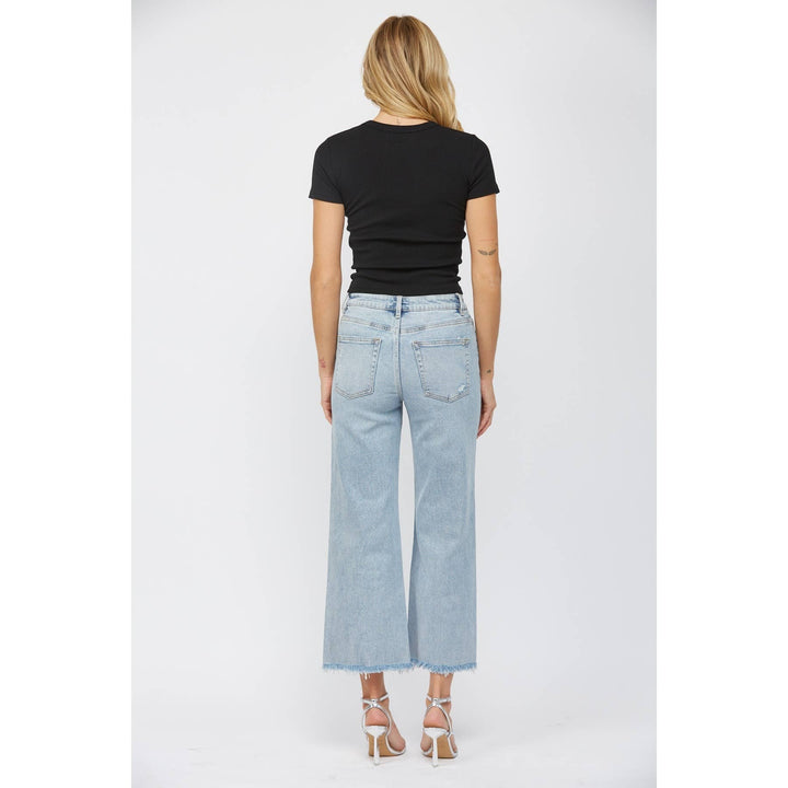 full back view of High-rise ankle wide-leg jeans in light wash with minimal distressing. Made from 98% cotton and 2% spandex.