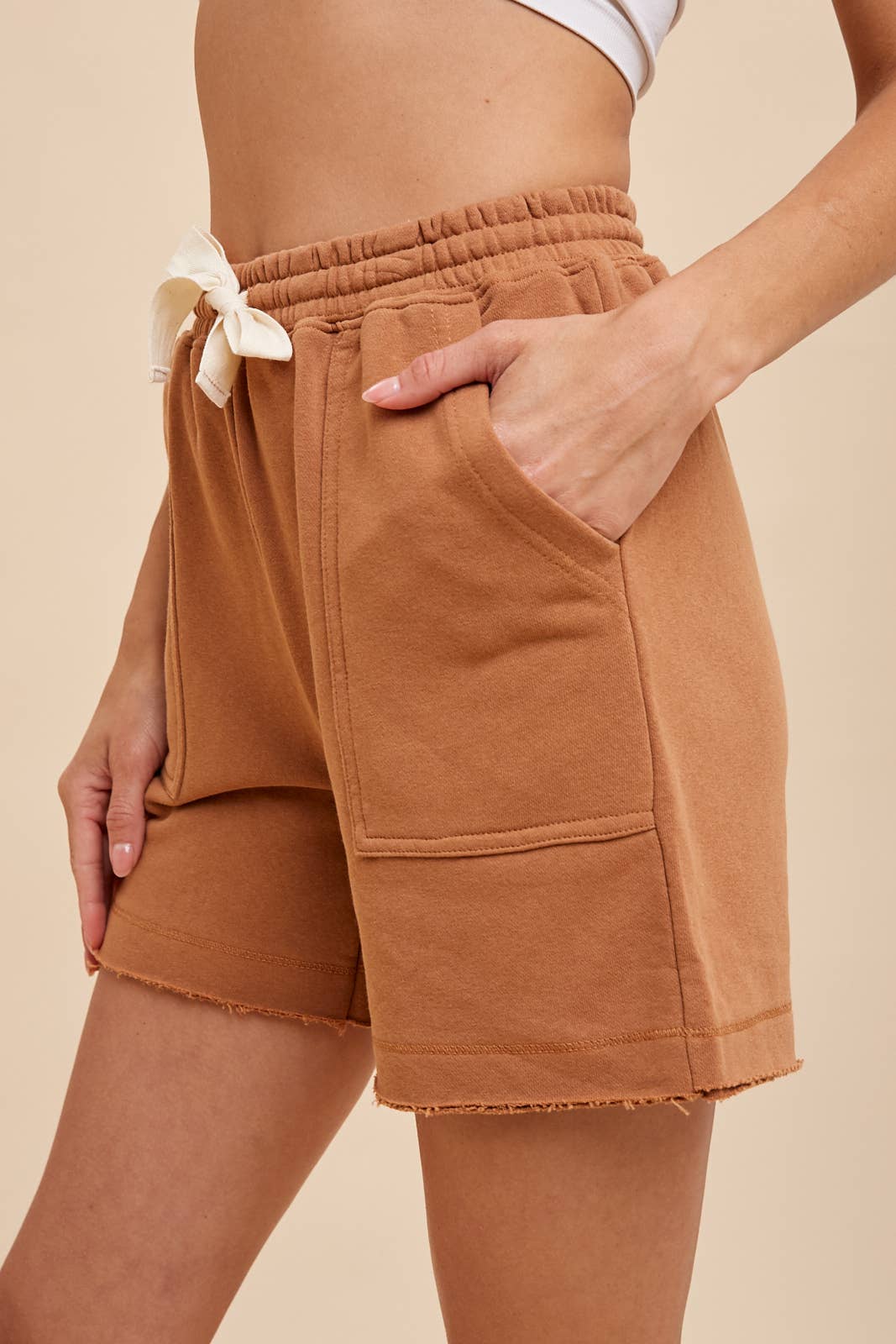 side view of Cammy Short - Garment-washed French terry shorts with an elastic waistband, cotton tape drawstring, double edge raw fray hem detail, and deep pockets.