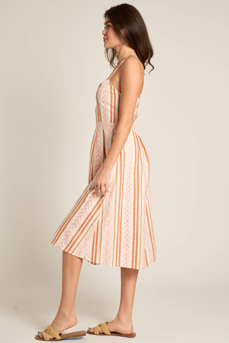 side view of Marie Back Cross Cami Midi Dress in white and coral, made from 98% cotton and 2% lurex. Features a back cross design. Model is 5'8" and wearing a size small.
